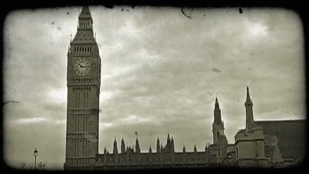 風になびく下のフラグとして 曇りの日にロンドンで有名なビッグベンの時計塔 ビンテージの様式化されたビデオ クリップ — ストック動画