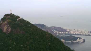 Rio De Janeiro, Brezilya - Haziran 2013: Kurtarıcı İsa'nın arka görünümüyle ünlü Corcovado dağının havadan görünümü. Görüntülerde arka planda atlanktik okyanus ve Rio de Janeiro şehri yer alıyor. Gökyüzü gri.