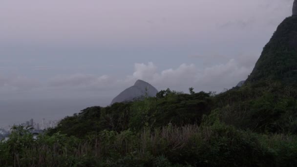 基督在高于巴西里约热内卢的科尔科瓦多向上平移镜头 摄影机镜头移权和山上直到这座雕像是在上部左上角的框架 天空被阴云塞满 — 图库视频影像