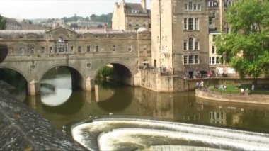 Pulteney köprü ve Weir arasında River Avon bir feribot ile pan. Ayrıca gösterilen yeşil ağaçlar ve taş binalar, Bath, İngiltere.