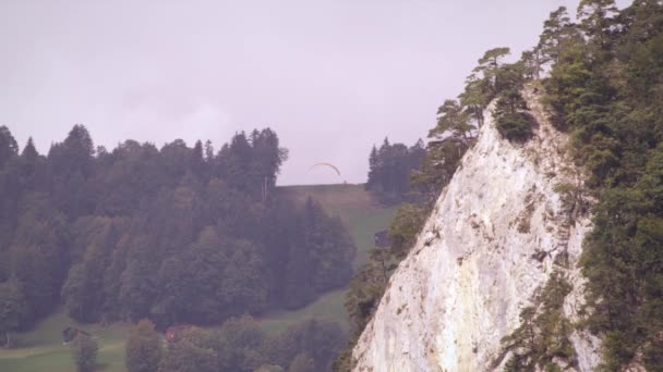 언덕에서 이륙하는 외로운 패러글라이더의 장거리 패러글라이더가 근처에서 떠다니는 — 비디오