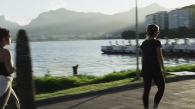 Rio de Janeiro - 18 Haziran 2013: yavaş hareket izleme atış Lagoa bir yolda yürüyen insan. Atış dağlar, su, ağaç, Bina ve trafik teknelerle yakalar.