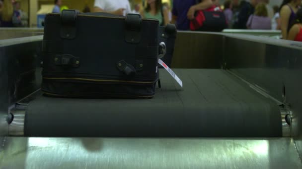 手荷物は空港で手荷物受取所に付いています 人々はバックグラウンドで自分のバッグを待ちます — ストック動画