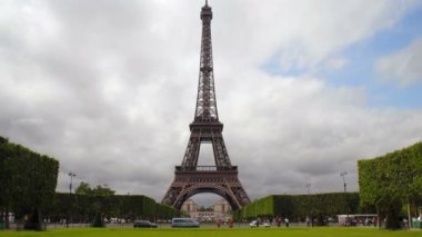 Hızlandırılmış tüm ihtişamını, Paris Eiffel Kulesi gibi bitişik park yükselir ve çevre sokak ön arka plan ve insanlar ve arabalar tarafından bulutlar waft süre peyzajlı ağaçlar geçip.