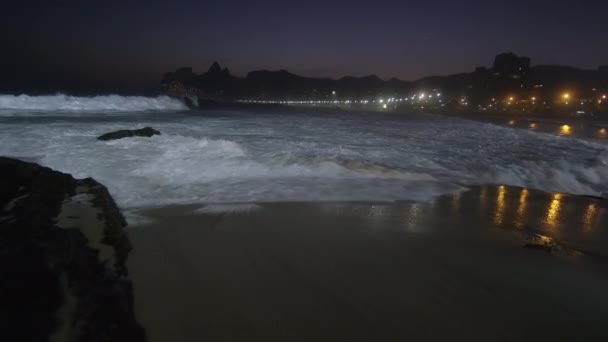 밤에이파네마 해변에서 파도가 이파네마 해변으로 흘러내리면서 슬로우 오른쪽으로 흘러내리는 도시의 — 비디오