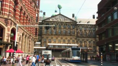 Royal Palace Amsterdam ön planda karşıya insanlarla cephe.