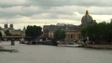 Hızlandırılmış Bibliotheque Mazarine, Seine Nehri ve Notre Dame Katedrali Paris, Fransa'da kuleleri gidiş bir feribot gösterilen.