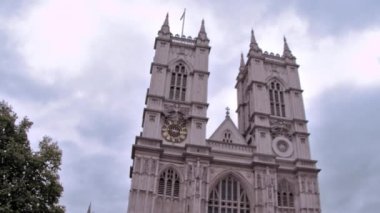 Londra'da bulutlu bir gökyüzüne karşı Westminster abbey kilisesinin düşük açılı panning görünümü, İngiltere.