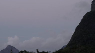 Corcovado Rio de Janeiro, Brezilya yukarıda İsa yukarı doğru kaydırma bir kadeh. Kamera tava çerçevesinin köşesine doğru ve tepeye kadar heykelin üst yaptı. Bulutlar gökyüzü bulutlu olduğu.