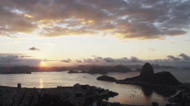 Yavaş yavaş aşağı tava Rio de Janeiro, Brezilya üzerinden günbatımı vurdu. Şehir ve bay görünümünde çerçevenin altındadır ve dağlar mesafe kontrast.