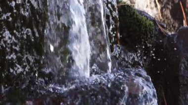 Closeup yavaş hareket beyaz su şelale gibi su sıçramalarına ve rock şarkıları.