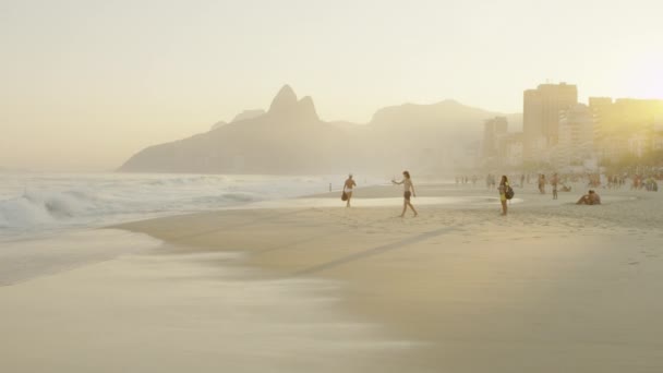 慢动作跟踪拍摄的人坐在和走在伊帕内马海滩在日落 在巴西里约热内卢拍摄 — 图库视频影像