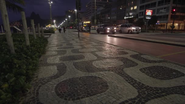 里约热内卢 2013年6月 科帕卡巴纳人行道图案的夜景拍摄 跑步者和骑自行车的人正在使用自行车道 跑步道 流量由中位数分隔 夜间拍摄 — 图库视频影像