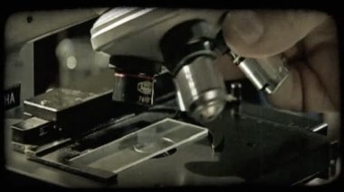 Yeşil sıvı damla ile plastik muayene plaka üzerinde konumlandırma mikroskop altında ve Doğrusunu bulmak için objektifler farklı boyutları arasında hareketli el kapatın. Vintage stilize video klip.