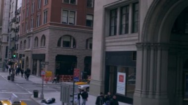 New York'taki küçük bir sokakta dolly fotoğrafı. Kavşakta taksiler ve kaldırımda yürüyen insanlar var..