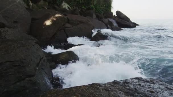 跟踪在日落时分在锯齿状 危险的巨石上冲击巨浪的慢动作 — 图库视频影像
