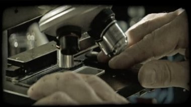 Yakın çekim yukarı en üstünde mikroskop göz deliklere göründüğü kadar plastik tabak lensler adamın yüzünü için mikroskop altında konumlandırma adamın elinden pan. Vintage stilize video klip.