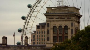 London Eye tekerleğinin ve yakınındaki binaların sabit bir fotoğrafı. Saint James Park'tan çekilen filmde, bazı ağaç tepelerinde ve gökyüzü de görülebilir..