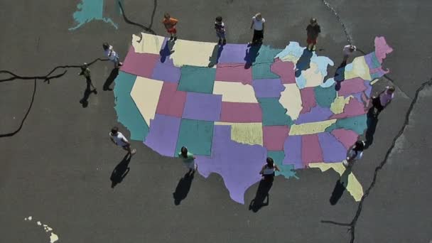 ユタ州の床で塗られた米国のマップの周り歩く子供の空中ショットは このショットは 日中屋外撮影されました — ストック動画