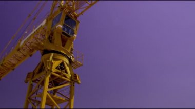 Oturmuş olduğu şantiyenin toan havadan görünümü, gökyüzüne karşı sarı bir vinç eğim atış.