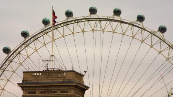 伦敦眼胶囊和它前面的建筑物的静止视图 楼顶上飘扬着一面英国国旗 天空多云 拍摄于圣詹姆斯公园 — 图库视频影像