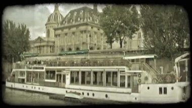 Ön planda diğer uzun tekne ile tekne paris, Fransa tarihi bina panoramik görünümü ve nehir dramatik bulut arka plan. Vintage stilize video klip.