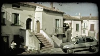 Roma, İtalya, Mayıs 2012 : Bir İtalyan şehrinde evinin önünde arabasına binen bir bayanın fotoğrafı. Vintage stilize video klip.