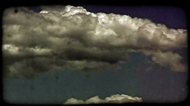 Beyaz ve gri bulutlar drift çerçevede alt kısmı boyunca ışık mavi gökyüzü ve arka planda diğer bulutlar ile hızlandırılmış. Vintage stilize video klip.