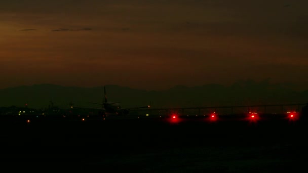 早朝にジャカレパグア空港で低空を飛行する飛行機の静的なショット 多くの光と小さな日光が見られる — ストック動画