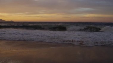 Yavaş çekim, Rio De Janeiro alacakaranlıkta Praia do Diabo (Devil's Beach) akan dalgaların ters pan atış