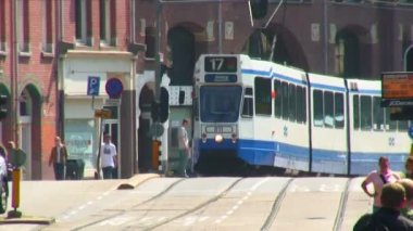 Kameranın doğru geliyor bir tramvay ve Hollanda'nın Amsterdam, ön planda geçen ikinci bir tramvay.