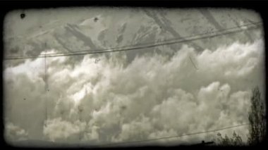 Telefon kablolarını karla kaplı Wasatch dağ zirveleri ve düşük asılı bulutlar arka planda görkemli sahne önünde yakınındaki kuş uçar. Vintage stilize video klip.