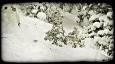 Beyaz ve yeşil giyinmiş kadın kayakçı, kar yağarken toz karla kaplı tepeden aşağı kayaklar, arka planda dökmeyen ağaçlar. Vintage stilize video klip.