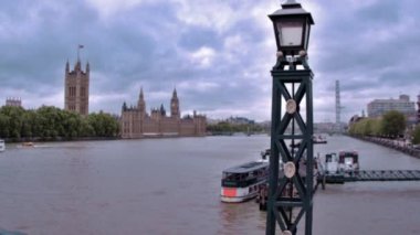 Londra, İngiltere'deki Thames Nehri boyunca Westminster Sarayı'ndan görünümünü seyahat.