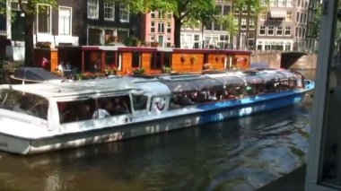 Amsterdam, Hollanda - 2013 yaklaşık: Hollanda'nın Amsterdam, bir kanal bir tekne-evi geçen feribot.