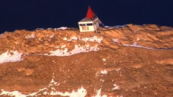 ユタ州の赤い山の上に建物の空中ショットは 駅に屋上や手紙 つの側面に に赤い布を持ってください — ストック動画
