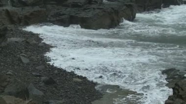 Cape Elizabeth, Maine Portland Head ışıkta kayalık bir plajda ihlal etmeleri yönünde dalgalar köpük.