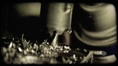 O metal matkap Close-Up nüfuz eder ve metal yüzey plaka endüstriyel ortamda yoluyla girer. Vintage stilize video klip.