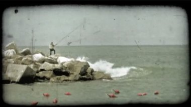 Geniş bir kapalı birkaç taş Balık tutma İtalyan bir adam vurdu. Vintage stilize video klip.