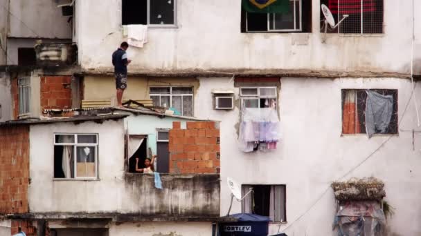 ジャネイロ ブラジル 2013 人とブラジルの貧民街で彼らの家の外の女の子のスローモーション 屋根とバルコニーで女の子に立っている人 — ストック動画