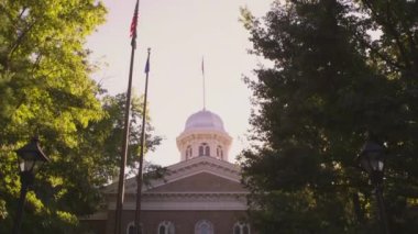 Carson City capitol binasının eğim çekimi. Kubbeden başlayıp girişe doğru eğilerek. Bayraklar ve binaya giren insanlar da görülebilir.