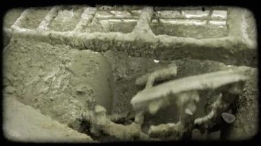 Büyük harç çimento makinesi kir, kaya ve çimento bir şantiyede dağınık çimento ile kaplı sandık altında churns, işçi karışımı içine daha fazla kir kürek gibi. Vintage stilize video klip.