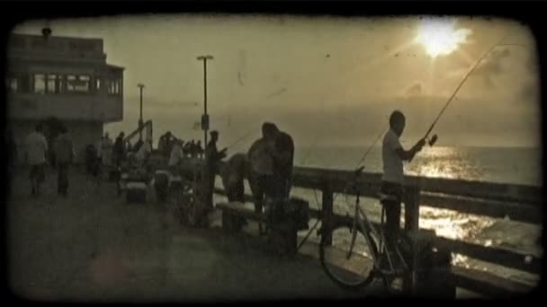 夕暮れ時 海岸のカリフォルニア州のドックのレールに沿って魚彼らのラインを鋳造クーラーと他の機器の設定多くの人々 忙しい釣りドック — ストック動画