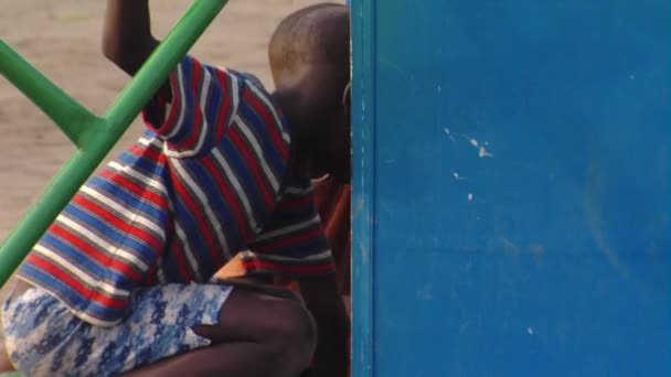 アフリカでのメリーゴーラウンドで遊ぶ二人の少年のショットを閉じる — ストック動画