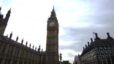 Londra'da Westminster Palace ve Big Ben saat kulesinin panoramik manzarası. Kamera sağdan sola hareket eder. Sadece bazı bulutlar ile oldukça açık bir gün.