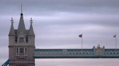 Kamera soldan sağa kaydırıyor, Tower Bridge'in iki kulesine ve Londra'daki inşaata odaklanıyor. İngiliz bayrağı ve İngiltere bayrağı onun üzerinde sallanıyor..