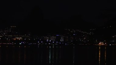 Waterfront ve kıyı, Rio de Janeiro şehrine bir timelapse vurdu. Binalar ışıklarını üzerine su yansıtan. Biraz su ripples.