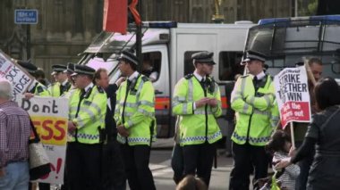 Londra - 9 Ekim 2011: Hungerford Köprüsü yakınlarında bir grup polisin sohbet edip protestoculara yakın dururken çekilmiş sabit bir fotoğrafı. Protestocular hükümetin sağlık sigortasını kesmelerine karşılar..