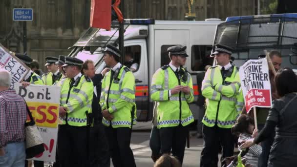 ロンドン 2011年10月9日 ロンドンのハンガーフォード橋の近くで 抗議者の近くでおしゃべりをして立っている警官のグループの静止したショット 抗議者は政府が医療保険を削減することに反対している — ストック動画