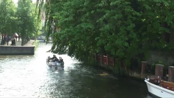 アムステルダム オランダで木の枝の下で運河を行くボートのアムステルダム オランダ 2012年年頃 ショット — ストック動画